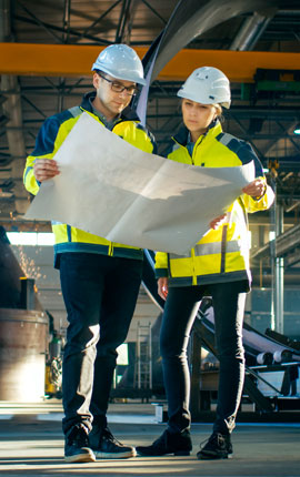Udyog Engineering engineers reviewing a technical drawing on site